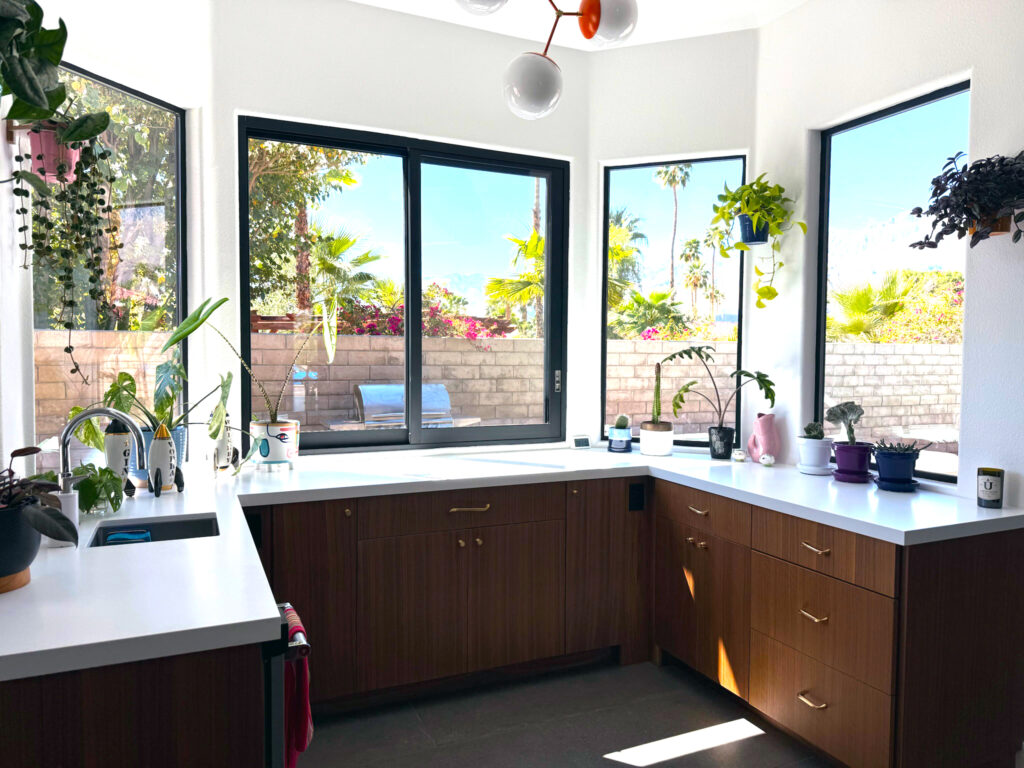 Sun Villas kitchen bar area with white countertops, walnut cabinetry, pass-through window to pool, and three-pane modern window installation.